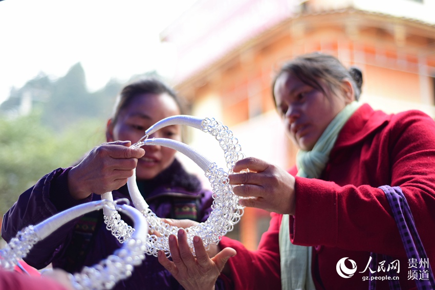 2月7日，在贵州省黔东南苗族侗族自治州丹寨县排调镇农村集市上，苗族妇女在选购银饰。